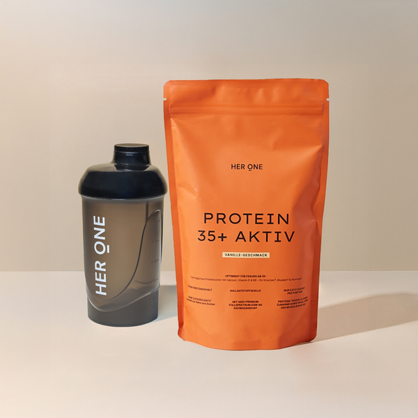 Schwarzer Shaker und orangefarbene Proteinpulverpackung mit der Aufschrift „Protein 35+ Aktiv“ auf einem Tisch.