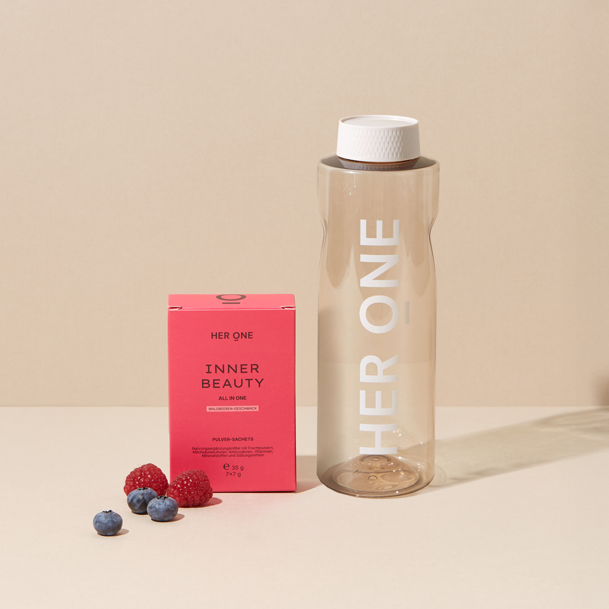 Her One Inner Beauty Package avec flacon et baies sur fond beige.