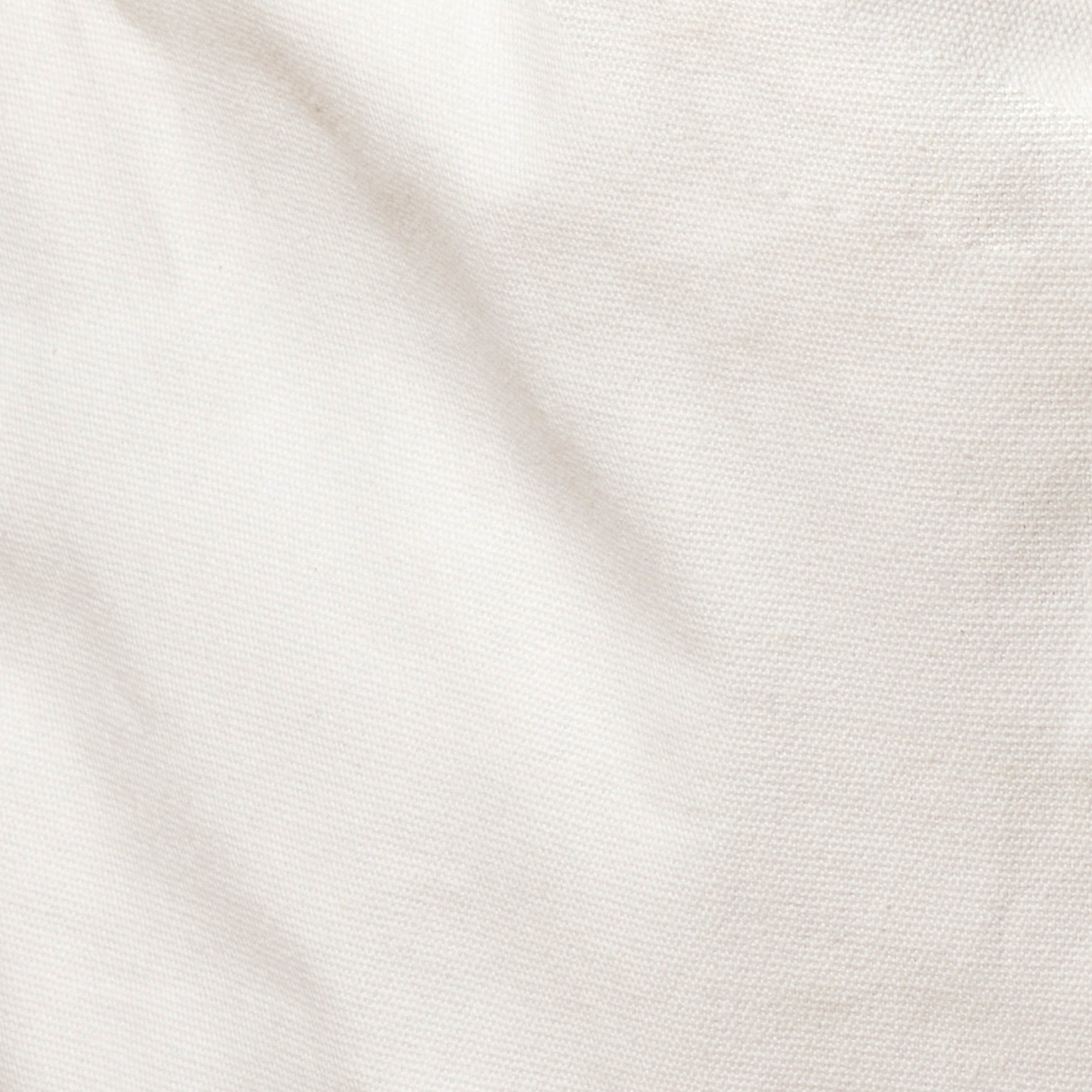 Close-up of crumpled, white linen fabric with visible texture.