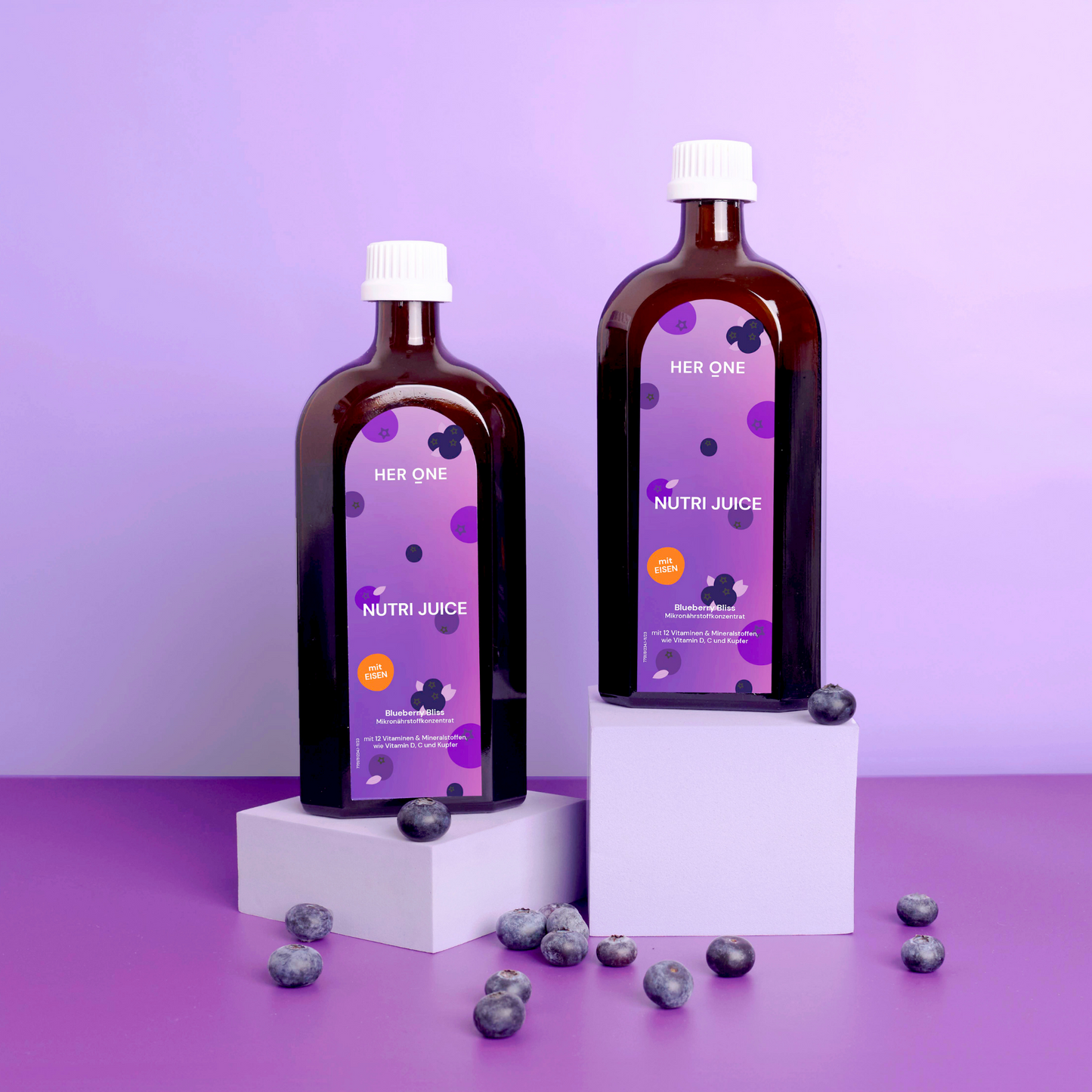 Two bottles with a purple label on white pedestals, surrounded by blueberries against a purple background.