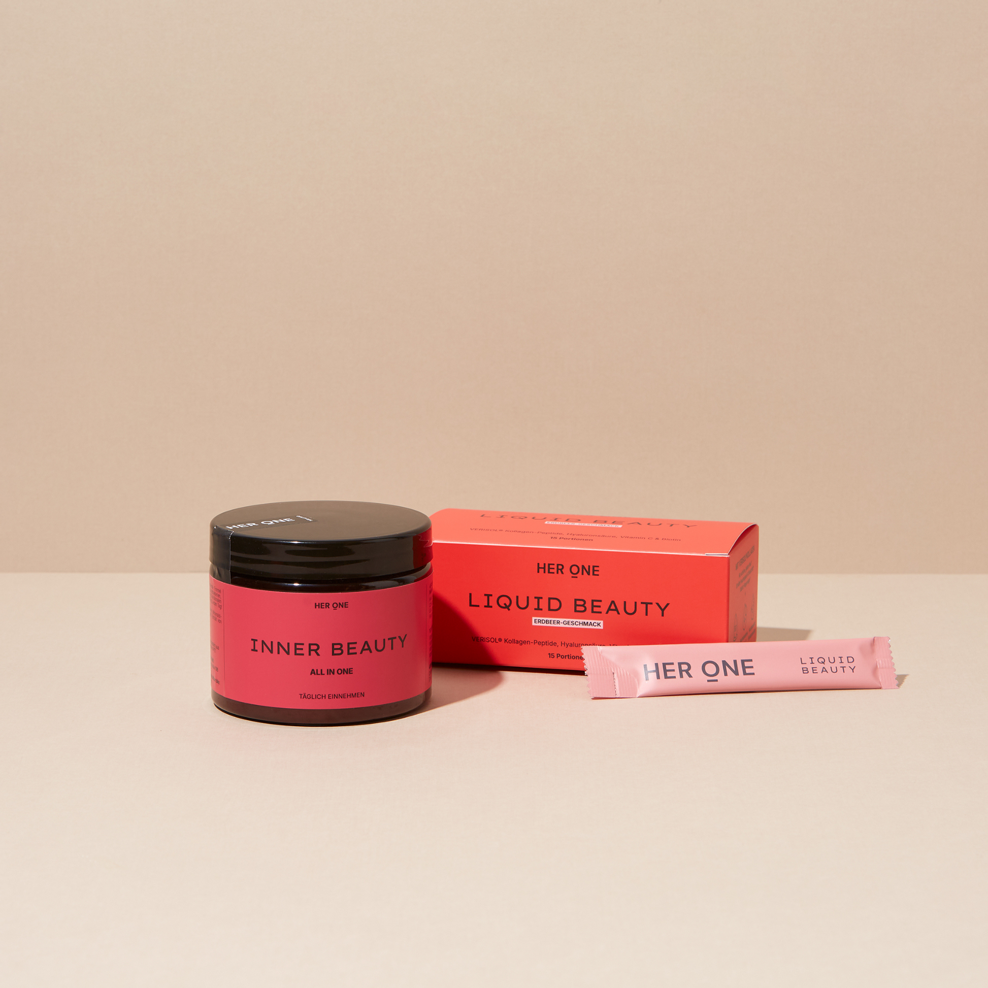 HER ONE INNER BEAUTY tin, LIQUID BEAUTY box and sachet arranged on a beige background.