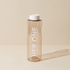 Transparent water bottle with a white lid and the inscription "HER ONE" against a beige background.