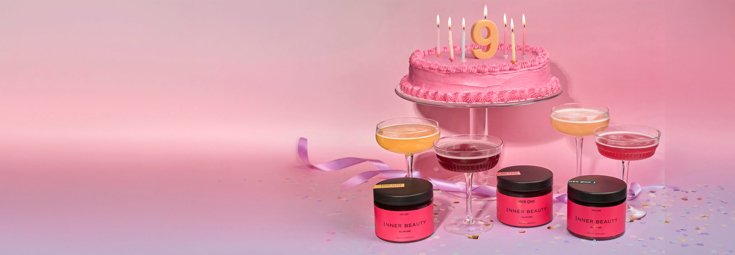 HER ONE Inner Beauty vor einer Geburtstagstorte mit der Zahl 9 und Cocktailgläsern auf rosa-violettem Hintergrund.
