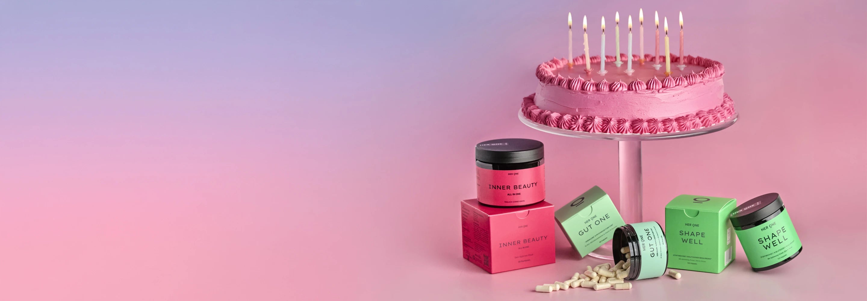 HER ONE Produkte neben einer Geburtstagstorte mit einer 9 auf rosa Hintergrund