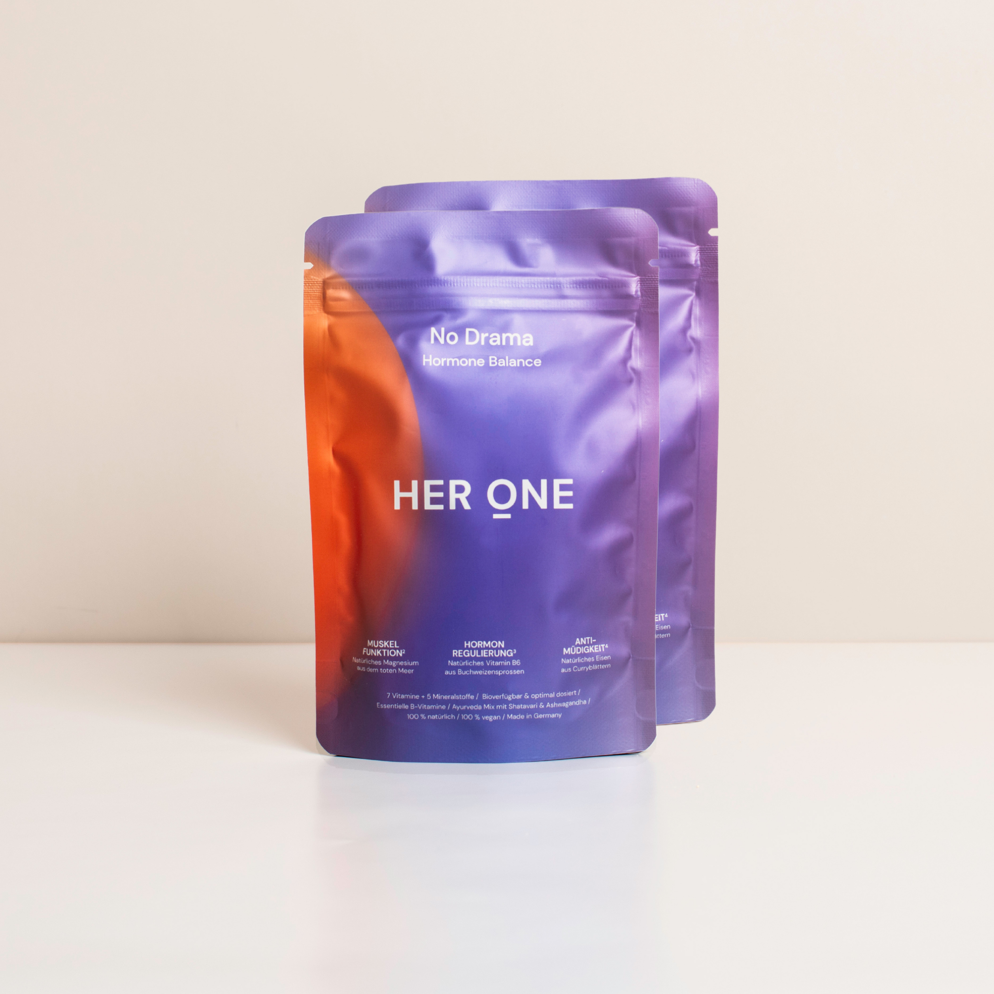 Zwei bunte Beutel mit der Aufschrift "HER ONE" und "No Drama Hormone Balance" auf weißem Hintergrund.