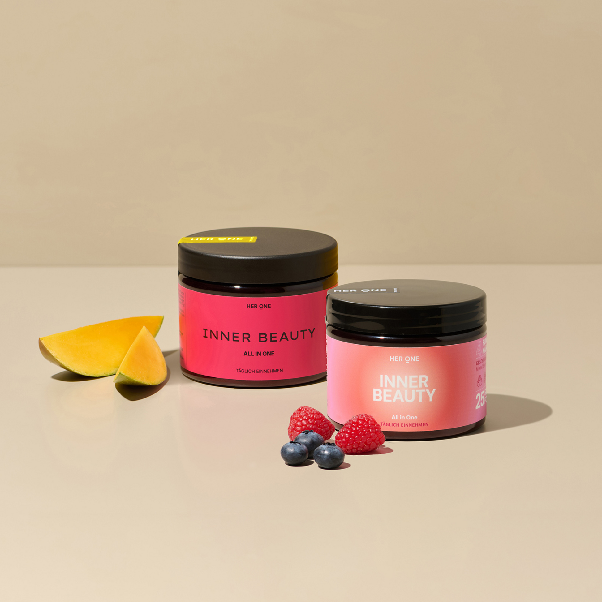 Zwei INNER BEAUTY Produkte nebeneinander. Das eine mit Mango Maracuja Geschmack, das andere mit Waldbeere. Die Produkte sind mit Früchten verziert und stehen leicht versetzt nebeneinander.