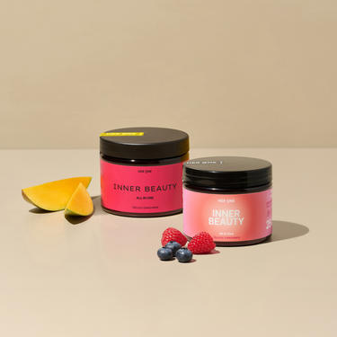 Zwei INNER BEAUTY Produkte nebeneinander. Das eine mit Mango Maracuja Geschmack, das andere mit Waldbeere. Die Produkte sind mit Früchten verziert und stehen leicht versetzt nebeneinander.