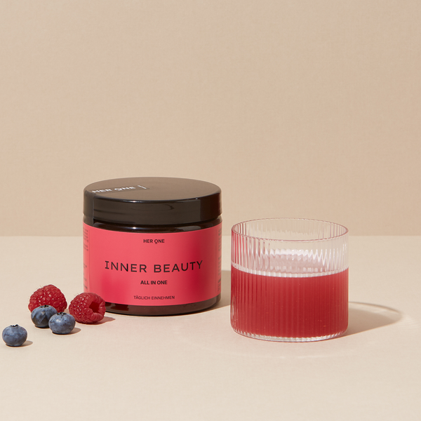 INNER BEAUTY Pulver Dose neben Glas mit zubereitetem Drink und frischen Beeren (Himbeeren, Blaubeeren).