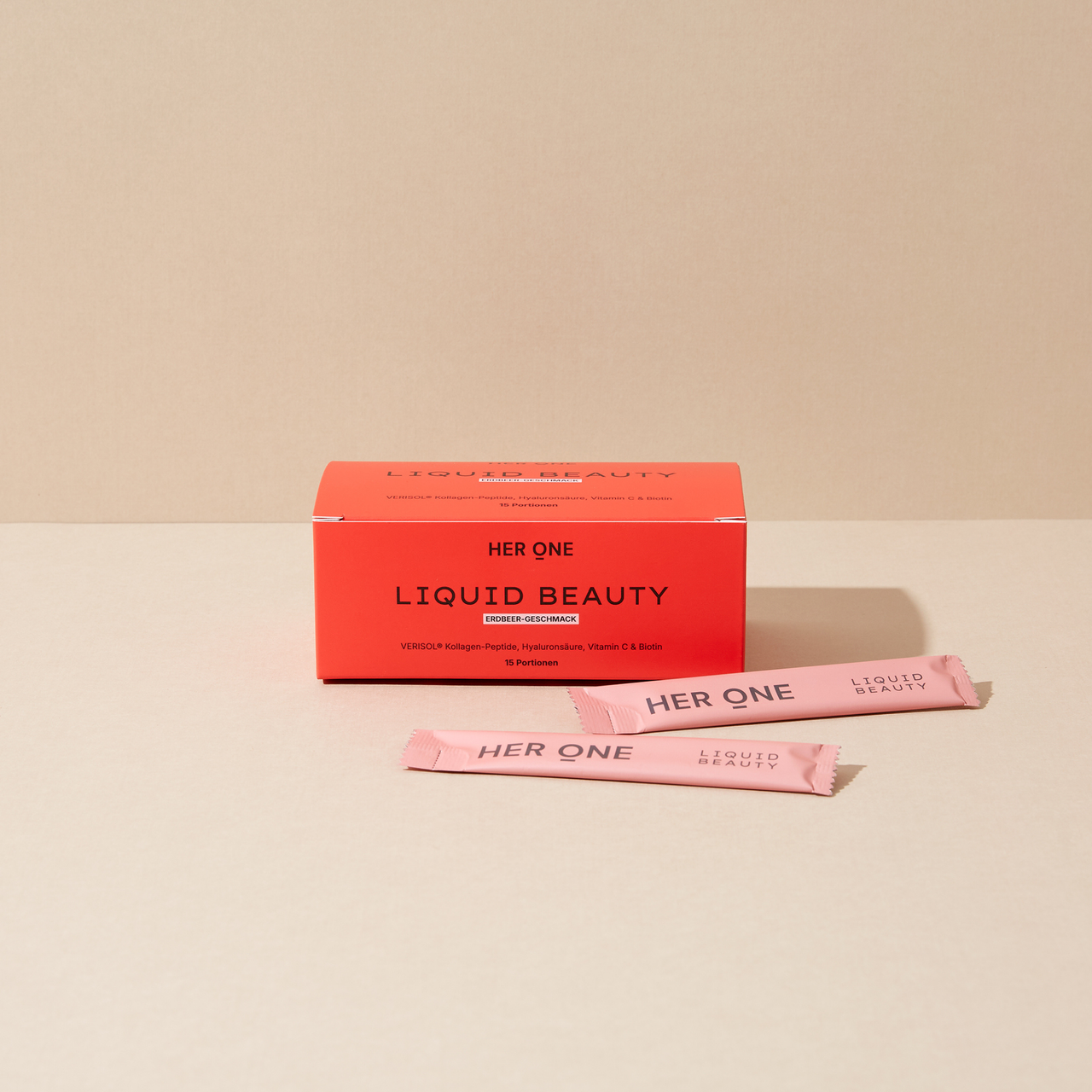 Produktfoto: rote HER ONE LIQUID BEAUTY Schachtel (Erdbeer) mit zwei rosa Sticks auf beigem Hintergrund