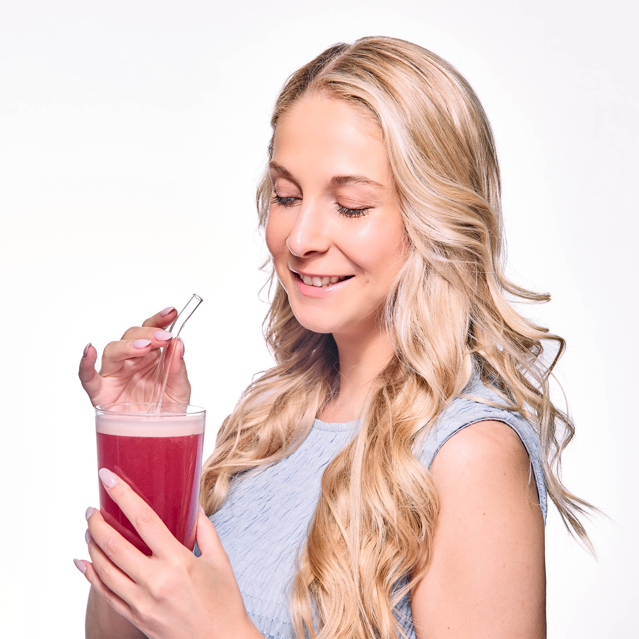 Una donna beve la bevanda al collagene liquido HER ONE