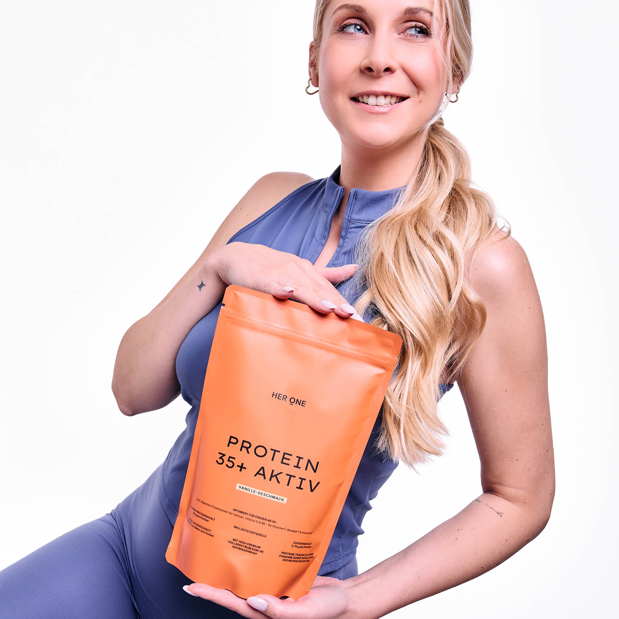 Frau hält HER ONE Protein 35+ Aktiv Produkt