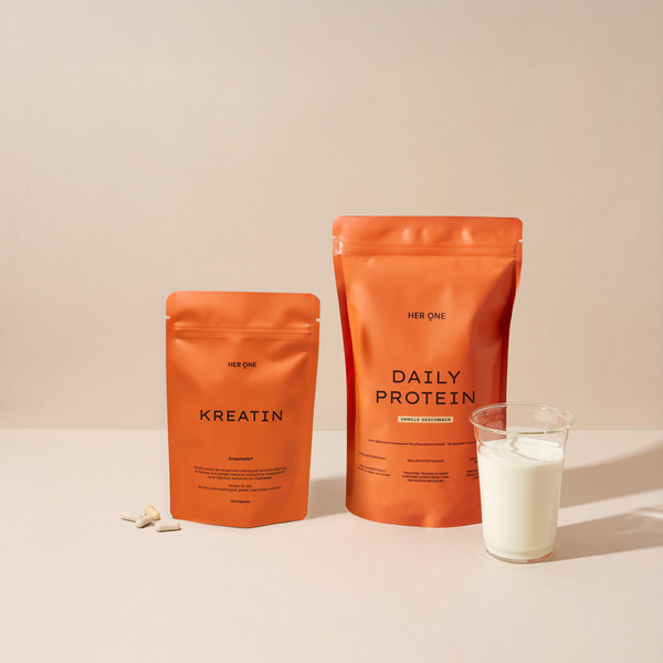 Orange Beutel HER ONE KREATIN und DAILY PROTEIN (Vanille) mit einem Glas Milch.