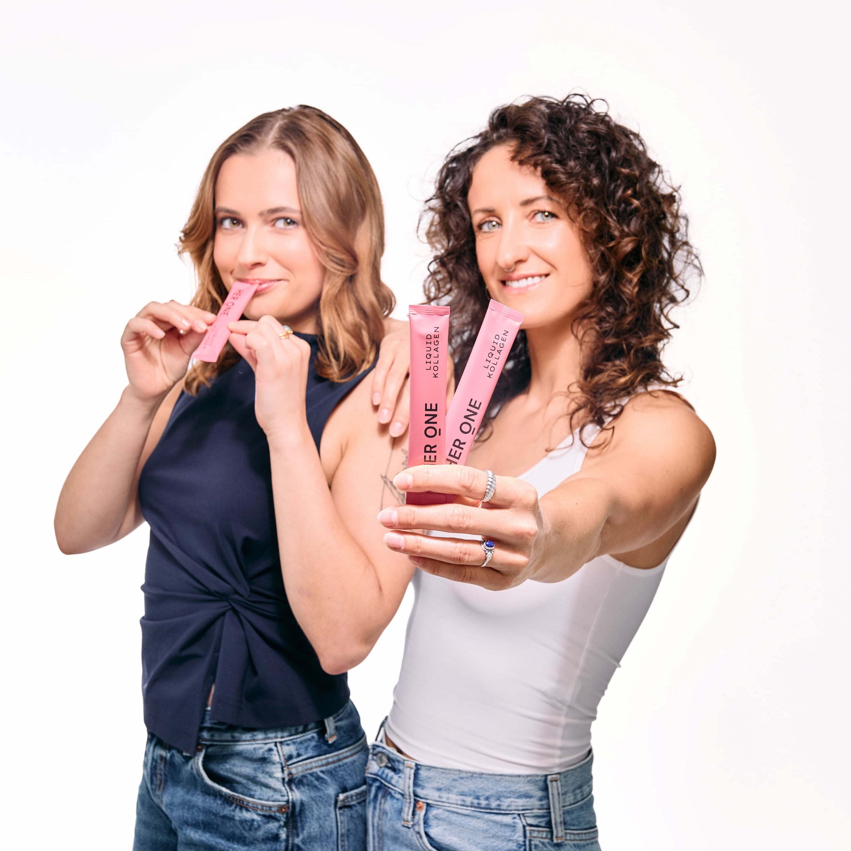 Women holding HER ONE Liquid Kollagen drinks