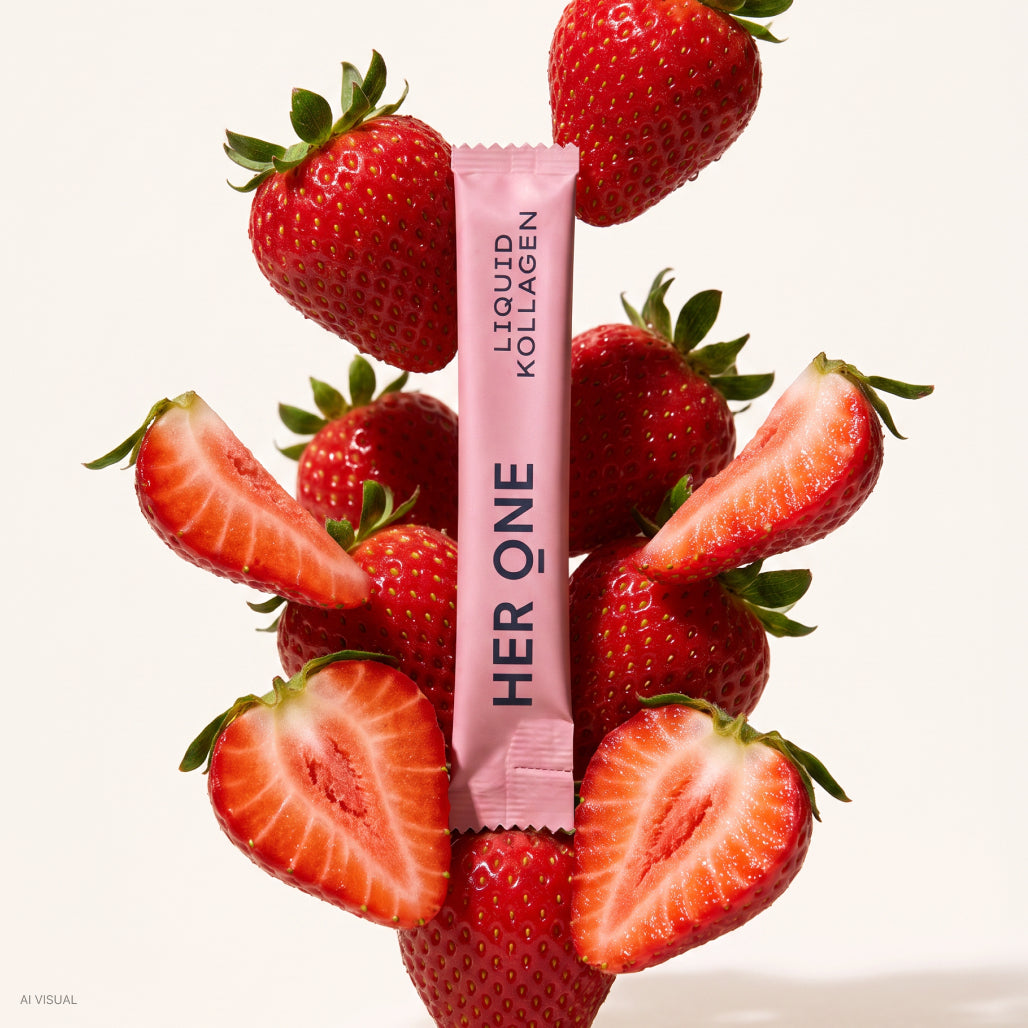 Bâtonnet de collagène liquide HER ONE à la fraise, parmi des fraises fraîches.