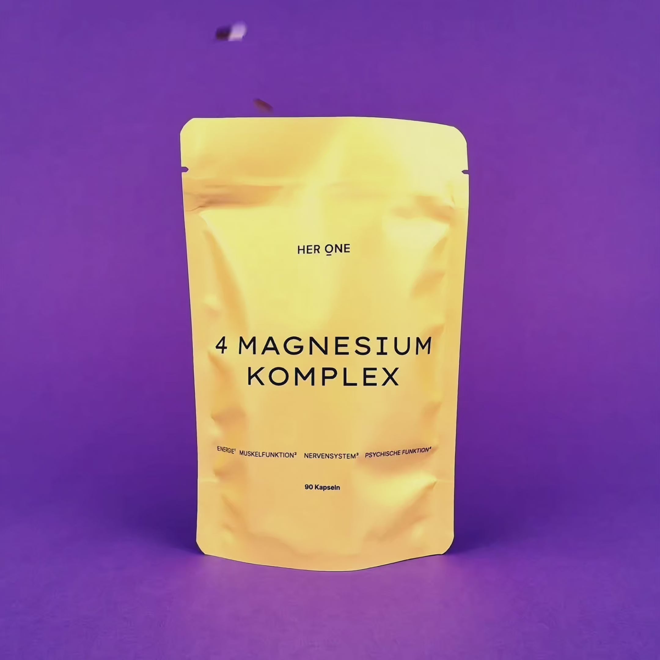 4 MAGNESIUM KOMPLEX auf violettem Grund, während buntes Konfetti von oben auf das Produkt herabfällt.