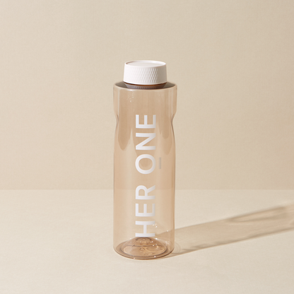 Transparent water bottle with a white lid and the inscription "HER ONE" against a beige background.