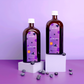 Two bottles with a purple label on white pedestals, surrounded by blueberries against a purple background.