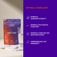 A package with food supplements and a glass of water in front of a purple information board with text.