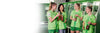 Four women in green football shirts laughing and holding bottles stand in a changing room.