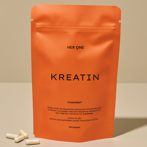 HERONE Creatine product in orange packaging, standing on a flat surface with three capsules of the product next to it.