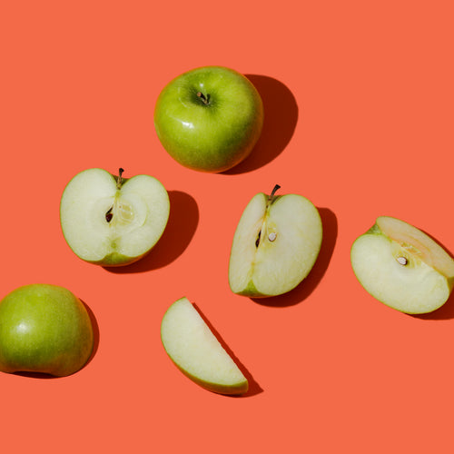 Green whole and cut heads lie on an orange background.