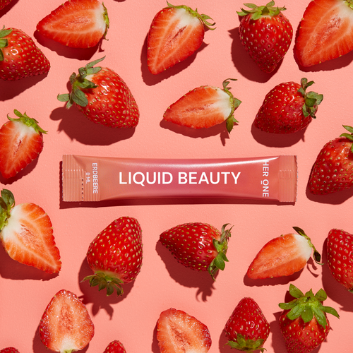 Un sachet de liquide rose portant l'inscription "LiquidBeauty" est entouré de fraises sur un fond rose.