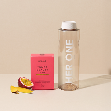 Boîte rose HER ONE INNER BEAUTY Sachets de poudre, fruit et une grande bouteille d'eau.