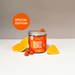 Un verreBurn Baby Burn" avec des bonbons à l'orange et des quartiers d'orange à côté, sur une table.