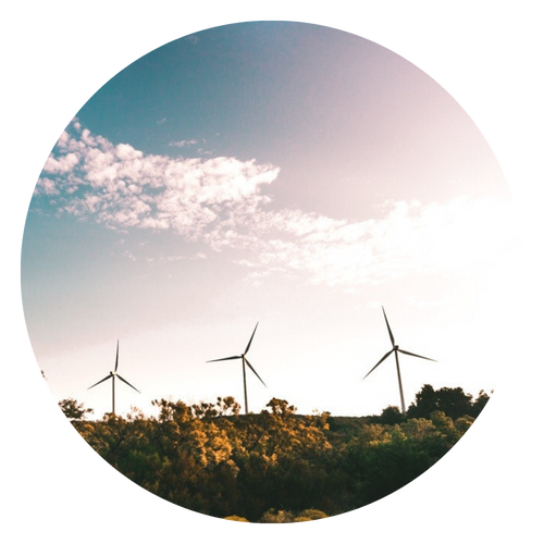 Tre turbine eoliche su una collina sotto un cielo nuvoloso al tramonto.