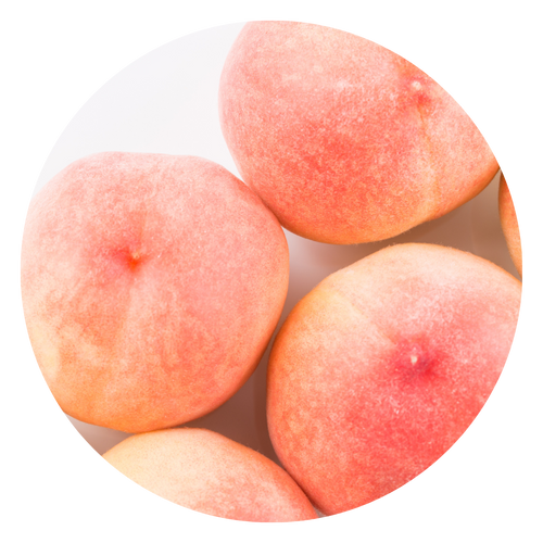 Verschillende sappige, roze-oranje perziken liggen dicht bij elkaar op een wit oppervlak.